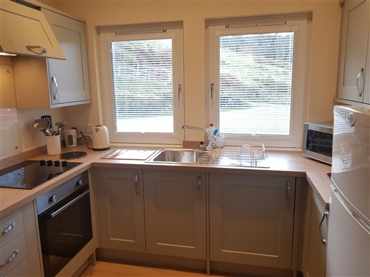 Kitchen with oven, hob, kettle, microwave and fridge freezer